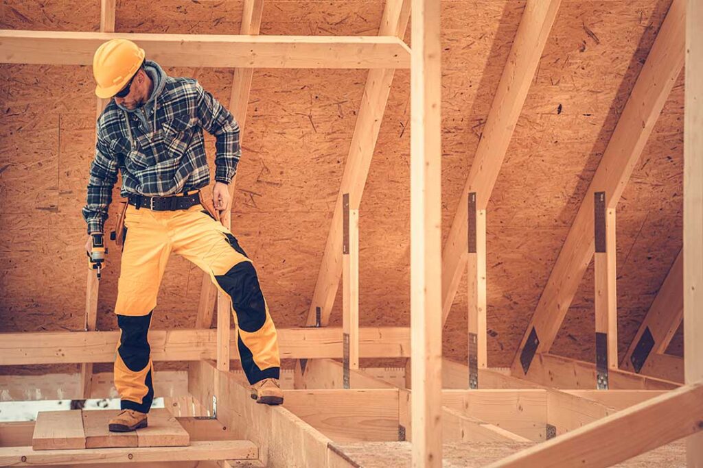 Homeowners review renovation plans, material samples, and a handwritten budget at a kitchen table.