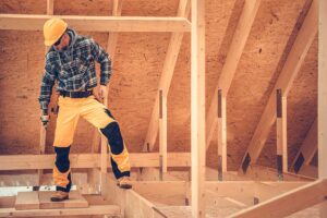 Homeowners review renovation plans, material samples, and a handwritten budget at a kitchen table.
